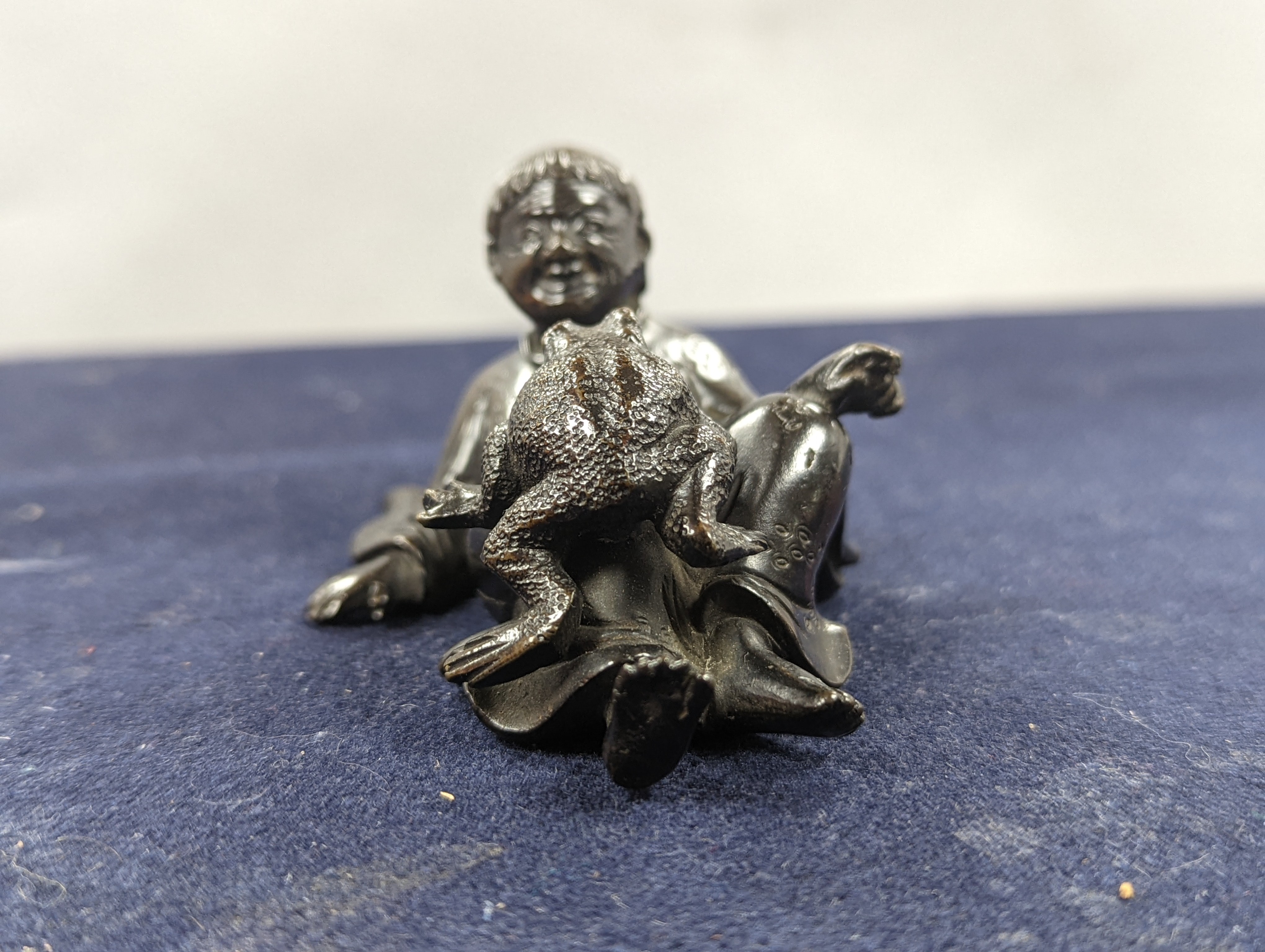 A Chinese bronze group of Liu Hai and a toad, wood stand and a bronze figure of a dog, 9cm